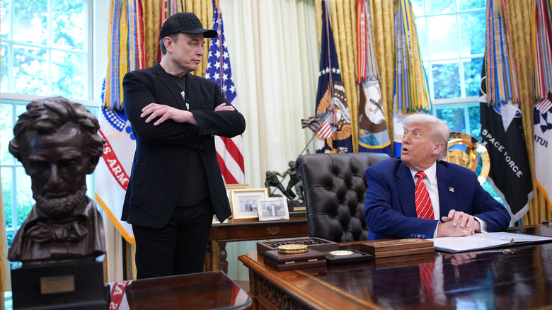 Elon Musk looking at Donald Trump in the Oval Office