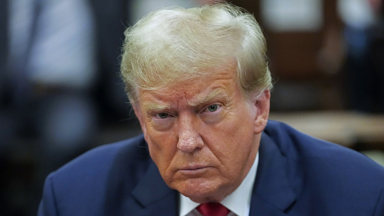 Donald Trump sitting in the courtroom scowling at the cameras