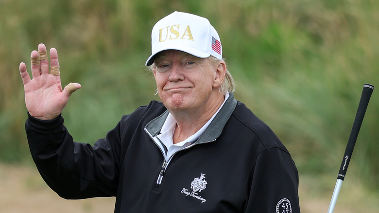 Donald Trump smiling on a golf course