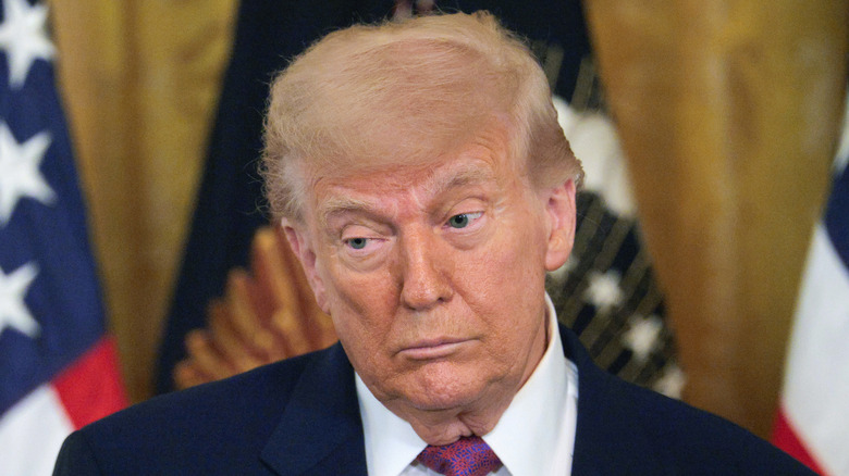 Donald Trump stands in front of the American flag