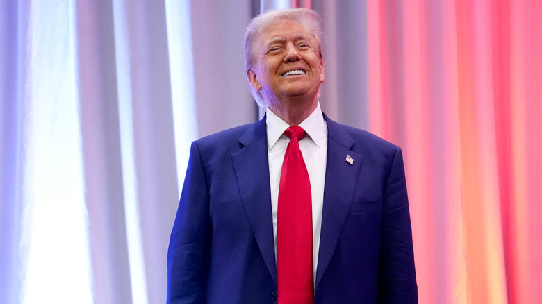 Donald Trump standing on stage and smiling