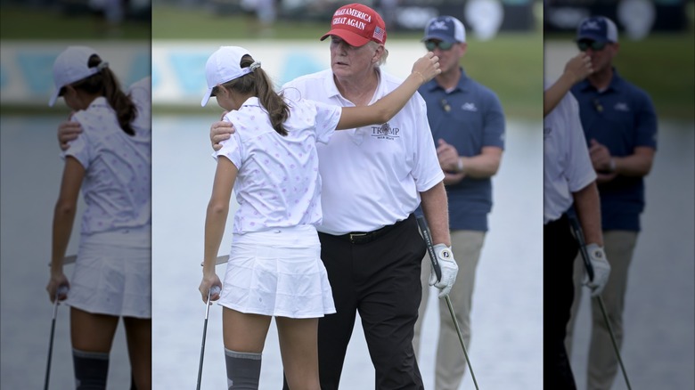 Donald and Kai Trump embrace on the golf course.