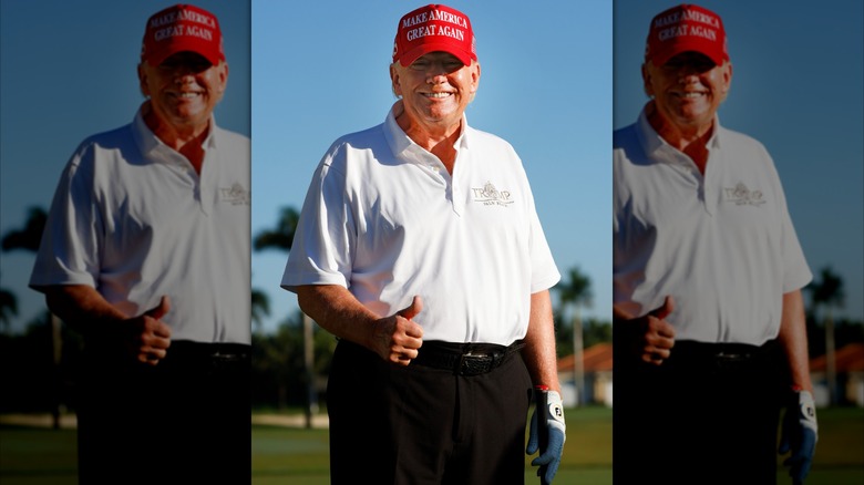 Donald Trump beams and gives a thumbs-up pose on the golf course.