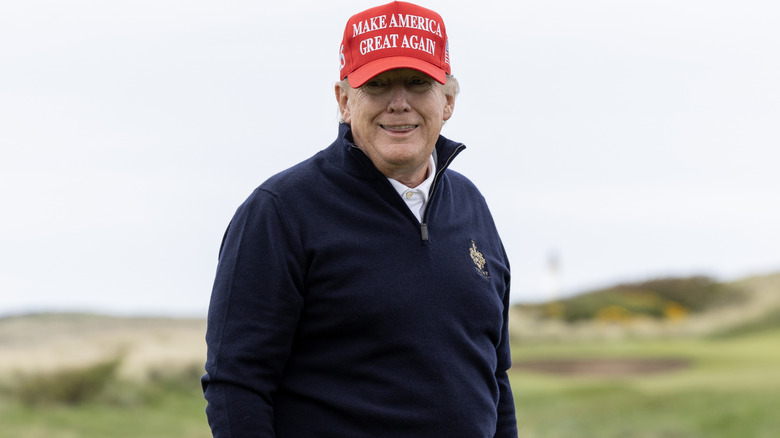 Donald Trump smiles on the golf course.