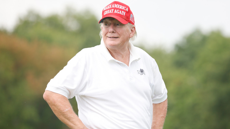 Donald Trump poses with his hands on his hips at the golf course.
