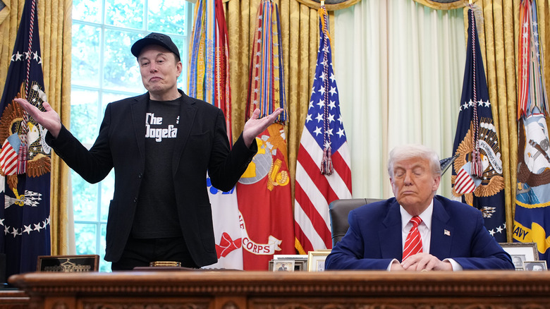 Elon Musk shrugging his shoulders as Donald Trump sits at his desk in the Oval Office