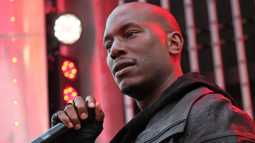 Tyrese Gibson in all black, looking out into the crowd during a live performance