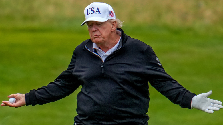 Donald Trump shrugs animatedly while playing golf.