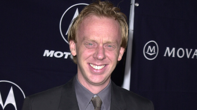 Mike White smiling in front of a dark background