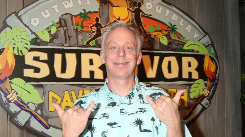 Mike White posing in front of Survivor logo