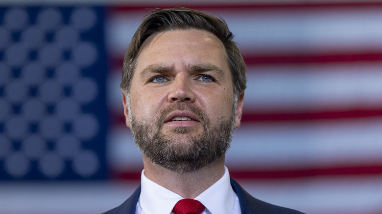 JD Vance standing in front of a flag