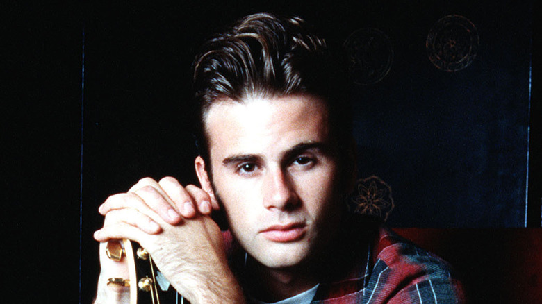 Jamie Walters posing next to his guitar