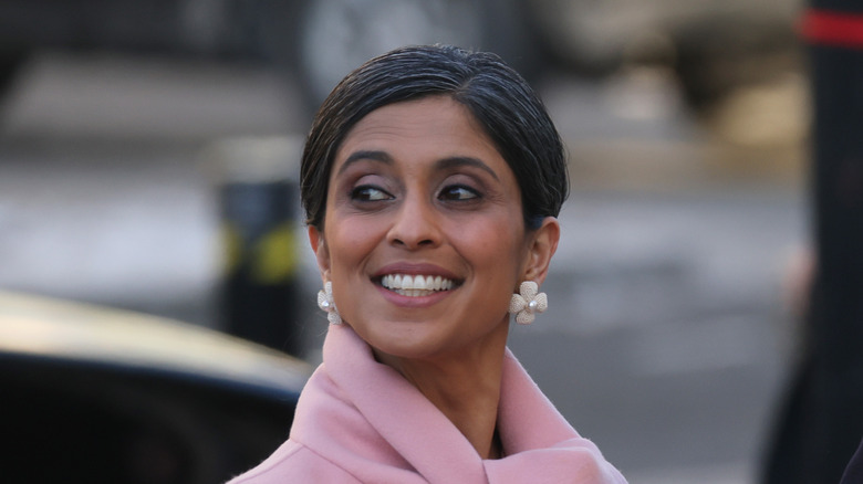 Usha Vance wearing large white flower earrings and smiling