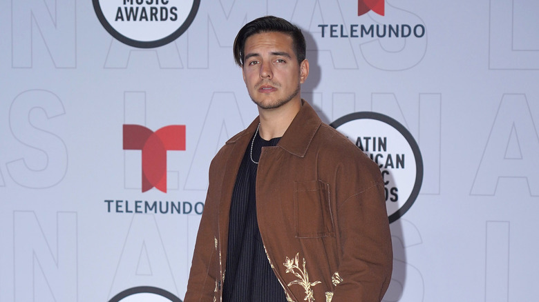 Vadhir Derbez posing on red carpet in brown jacket