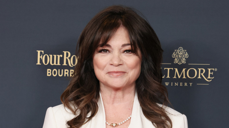 Valerie Bertinelli smirking wearing white suit