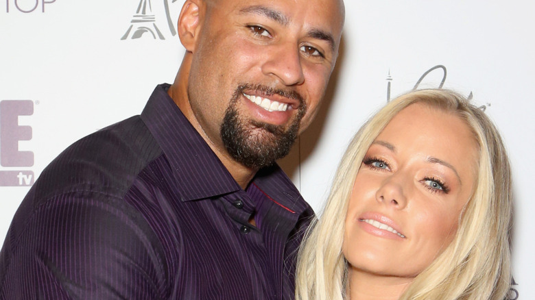 Kendra Wilkinson poses with Hank Baskett on red carpet
