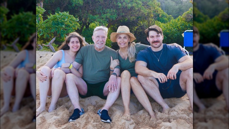 Chuck Norris posing on the beach with his wife and their twins.