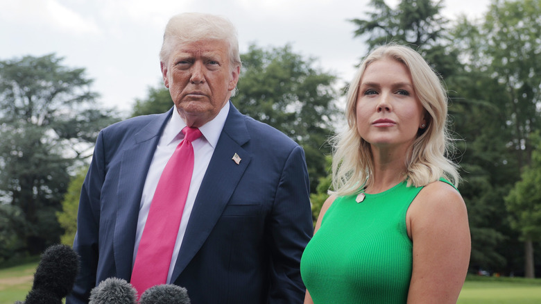 President Donald Trump speaking to the media while Karoline Leavitt stands by his side
