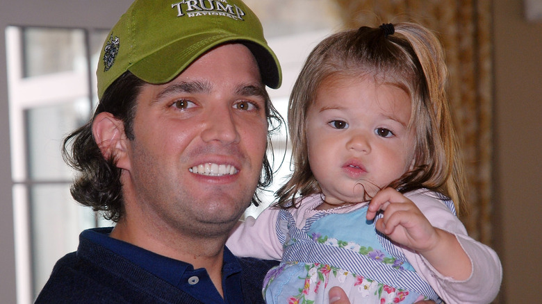 Donald Trump Jr. holding Kai