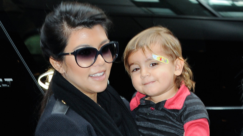 Kourtney Kardashian holding Mason Disick