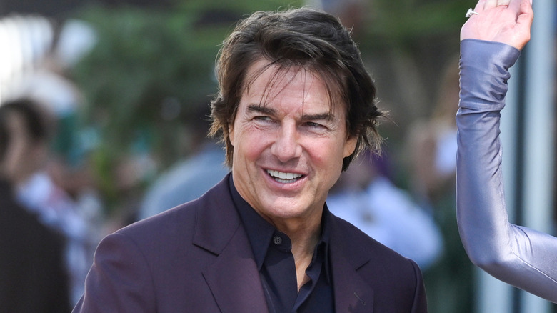 Tom Cruise smiling at busy event.