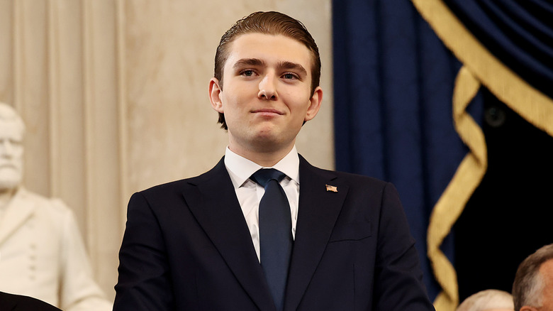 Barron Trump smirking in a suit