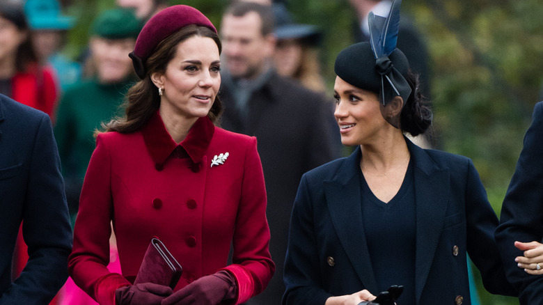 Kate Middleton and Meghan Markle talking.