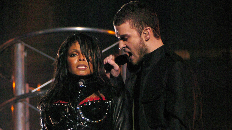 Janet Jackson wearing a black studded leather ensemble with Justin Timberlake in a black jacket holding a microphone