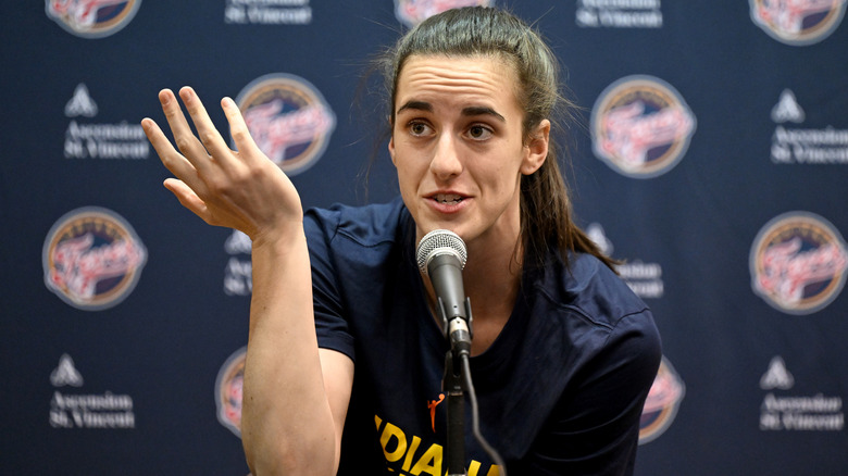 Caitlin Clark at a microphone 