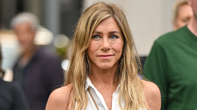 Jennifer Aniston wearing a white collared sleeveless top
