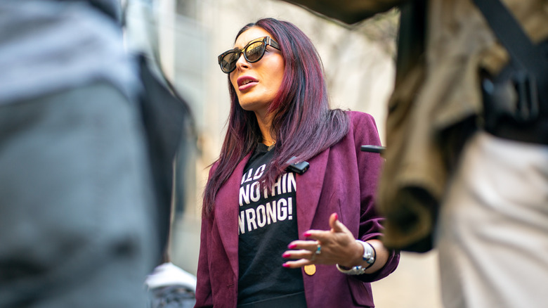 Laura Loomer in sunglasses and a purple jacket
