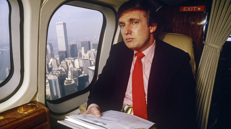 Donald Trump in helicopter with stack of papers