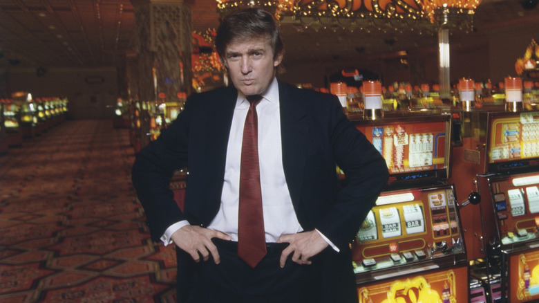 Donald Trump posing with hands on hips inside casino