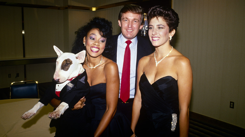 Donald Trump posing with two women and Spuds MacKenzie