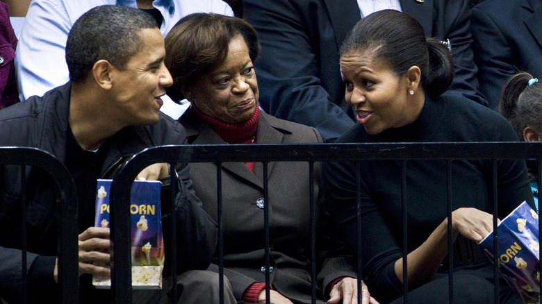 Barack Obama, Marian Robinson, and Michelle Obama watching a basketball game at George Washington University