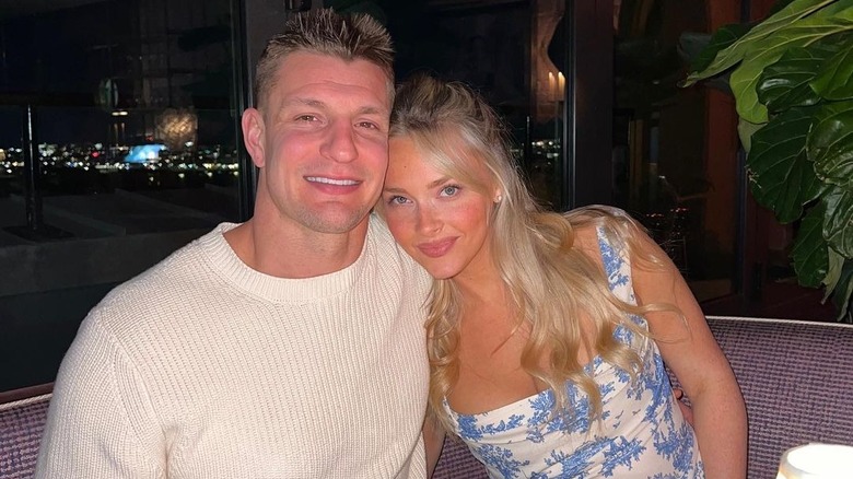 Camille Kostek resting head on Rob Gronkowski's shoulder