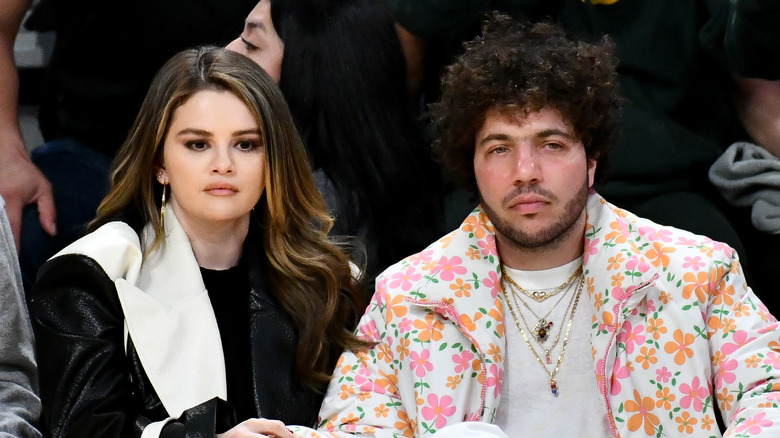 Selena Gomez and Benny Blanco sitting at sports game