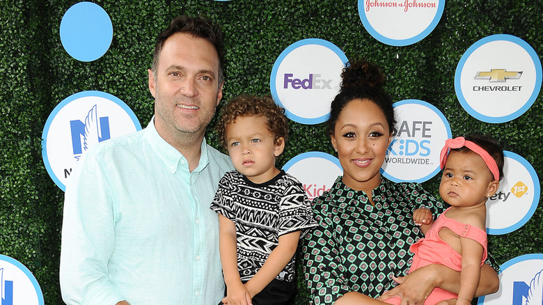 Tamera Mowry and Adam Housley posing with children