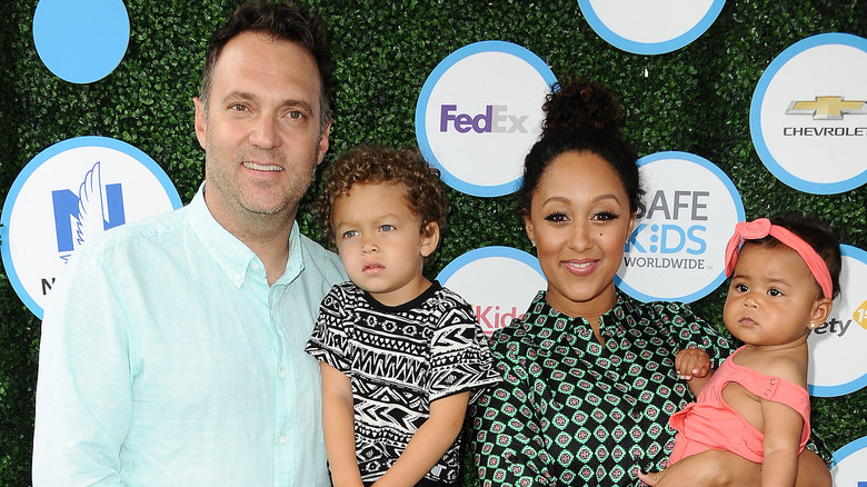 Tamera Mowry and Adam Housley posing with children