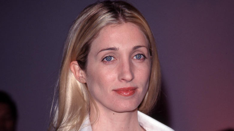 Carolyn Bessette-Kennedy gazes away from the camera while wearing minimalist makeup.