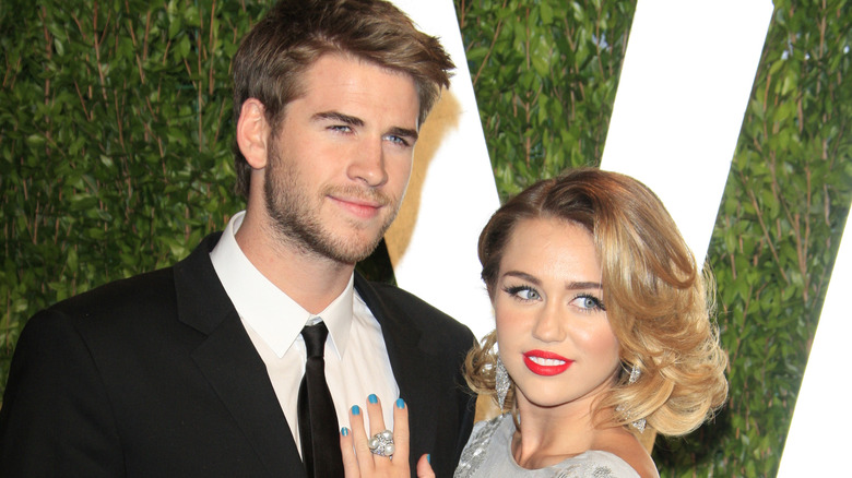 Miley Cyrus holding Liam Hemsworth