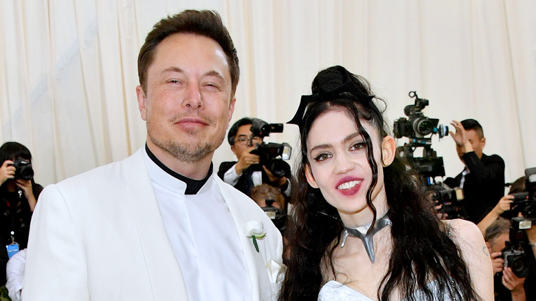 Elon Musk squinting Grimes smiling