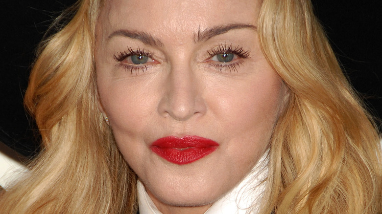 Madonna wearing a black hat and red lipstick