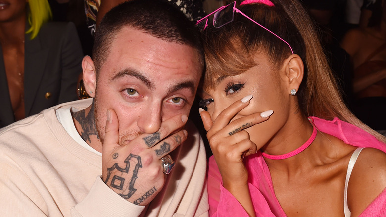 Mac Miller and Ariana Grande smiling and covering their faces together