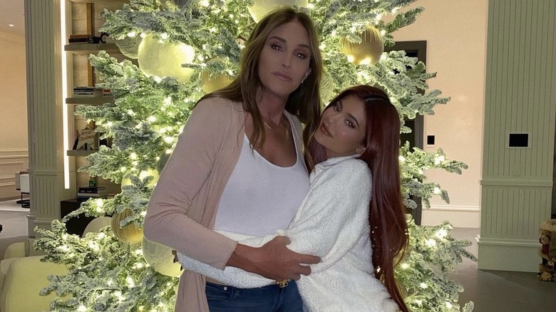 Caitlyn Jenner hugging Kylie Jenner, in front of a Christmas tree, at home, neither smiling 