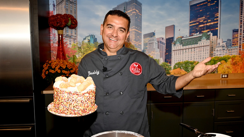 Buddy Valastro posing with a cake in 2022