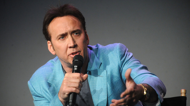 Nicolas Cage speaking into a microphone.