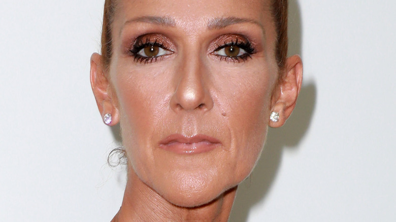 Celine Dion not smiling hair in bun with diamond earrings