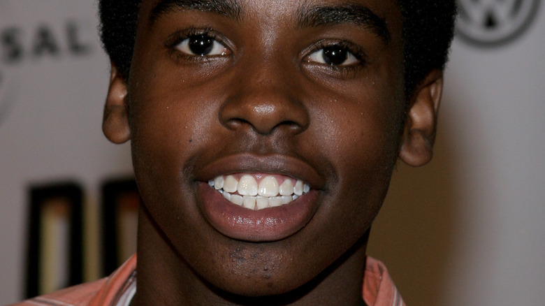 Daniel Curtis Lee smiles in an orange top