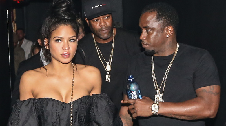 Cassie and Diddy, both wearing black, alongside a bodyguard